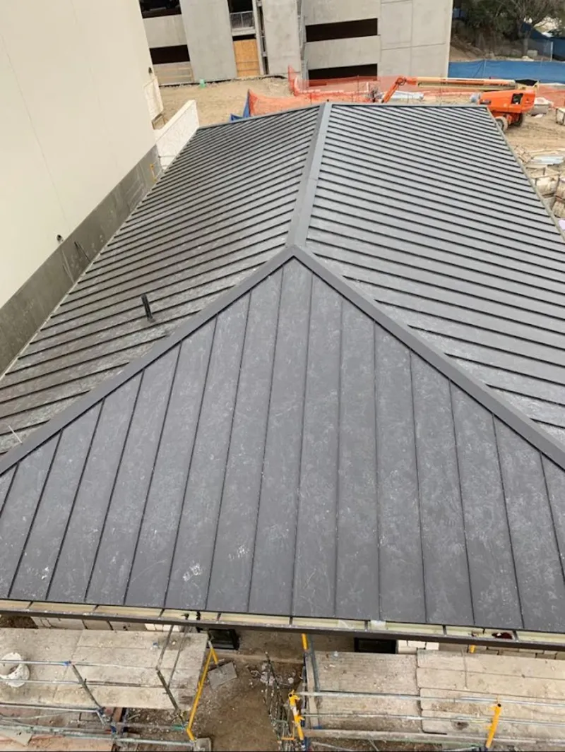 Commercial metal roof construction with crane equipment in Placerville